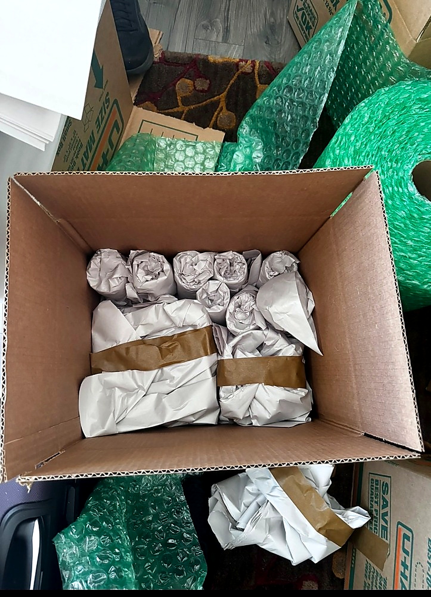 Fragile items individually wrapped and packed into a moving box