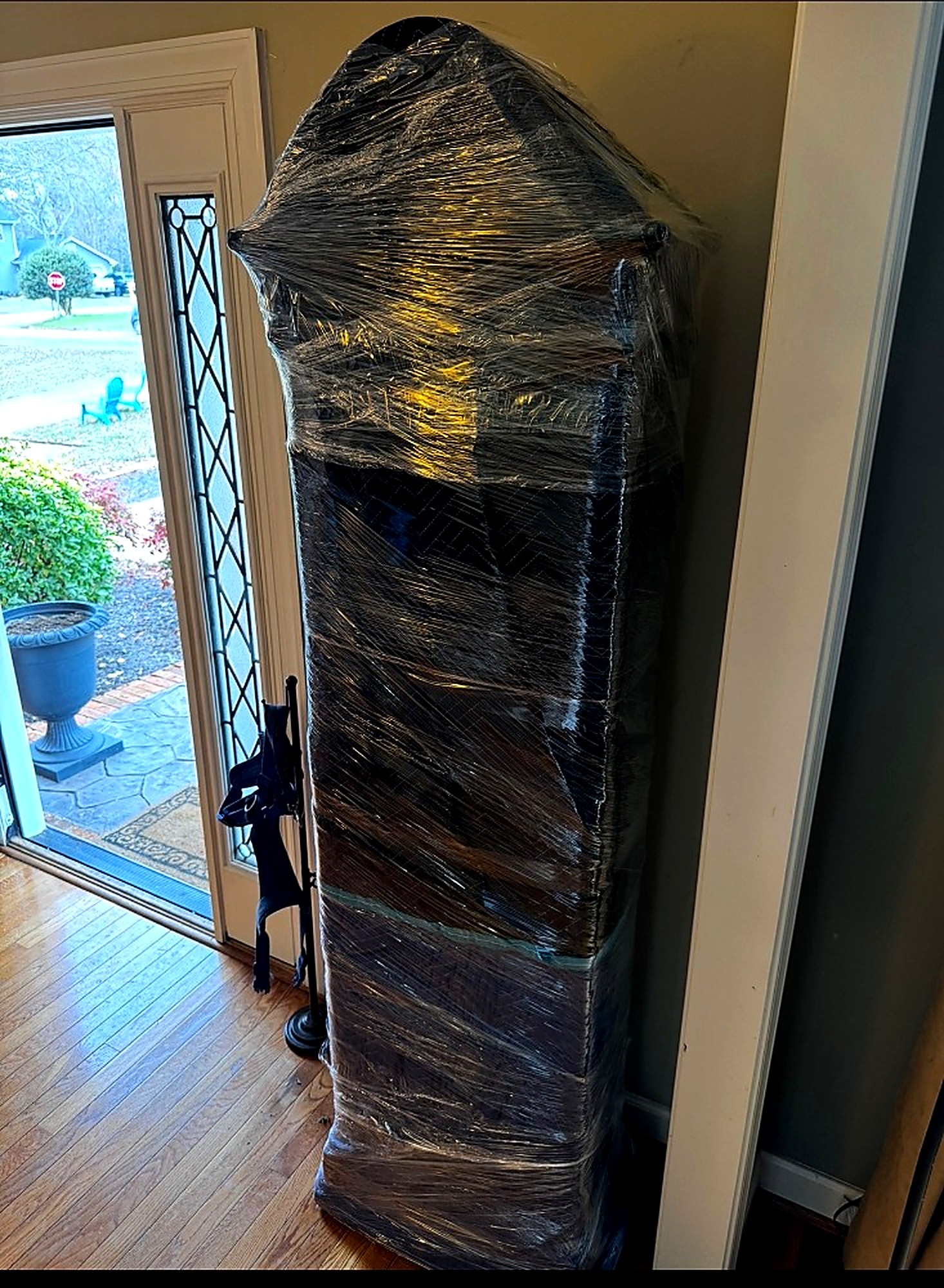 Tall cabinet wrapped in protective plastic inside a home